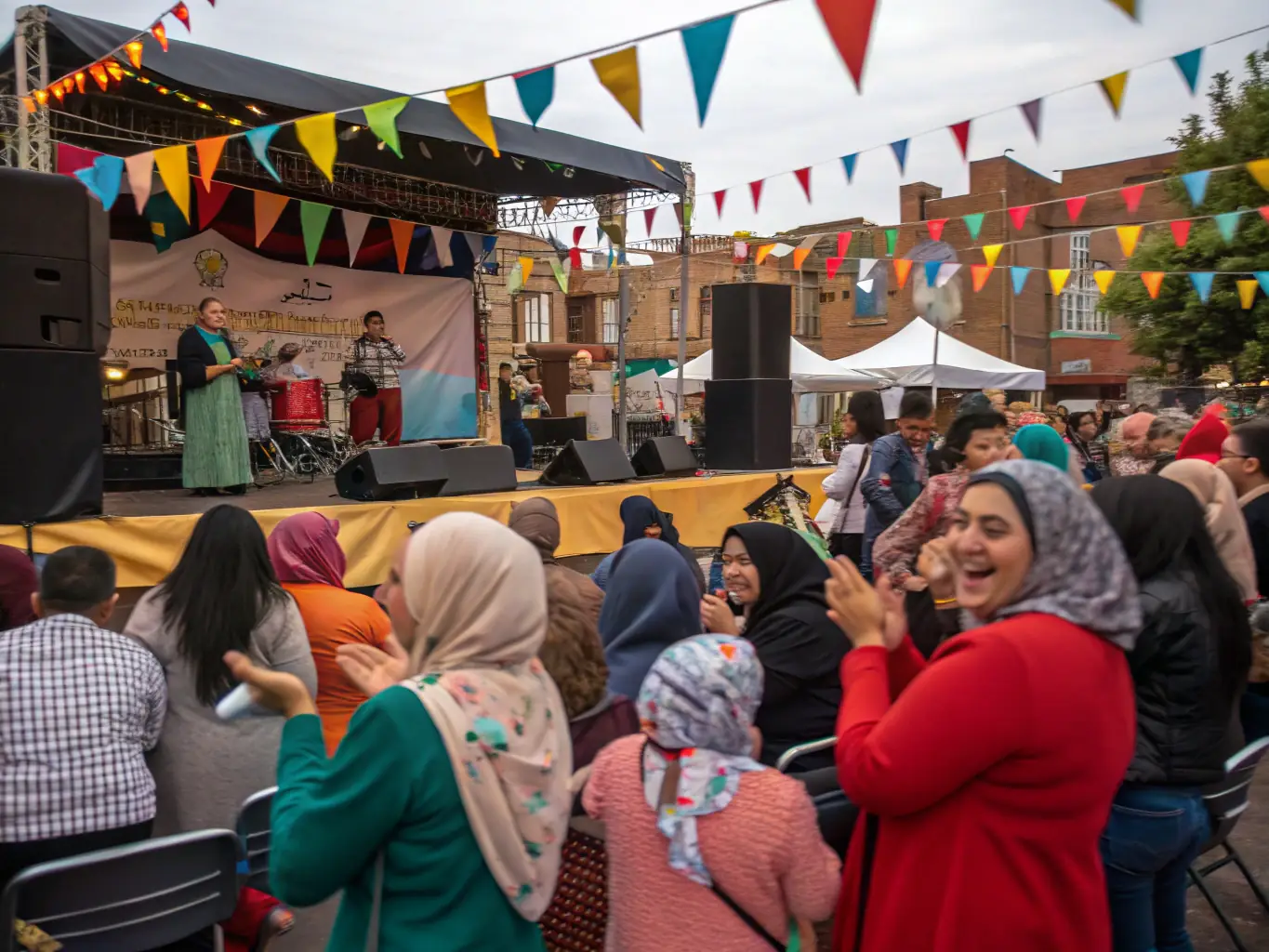 A lively photograph of a community event at MJCVP, featuring local talents performing on stage and a diverse audience enjoying the show.